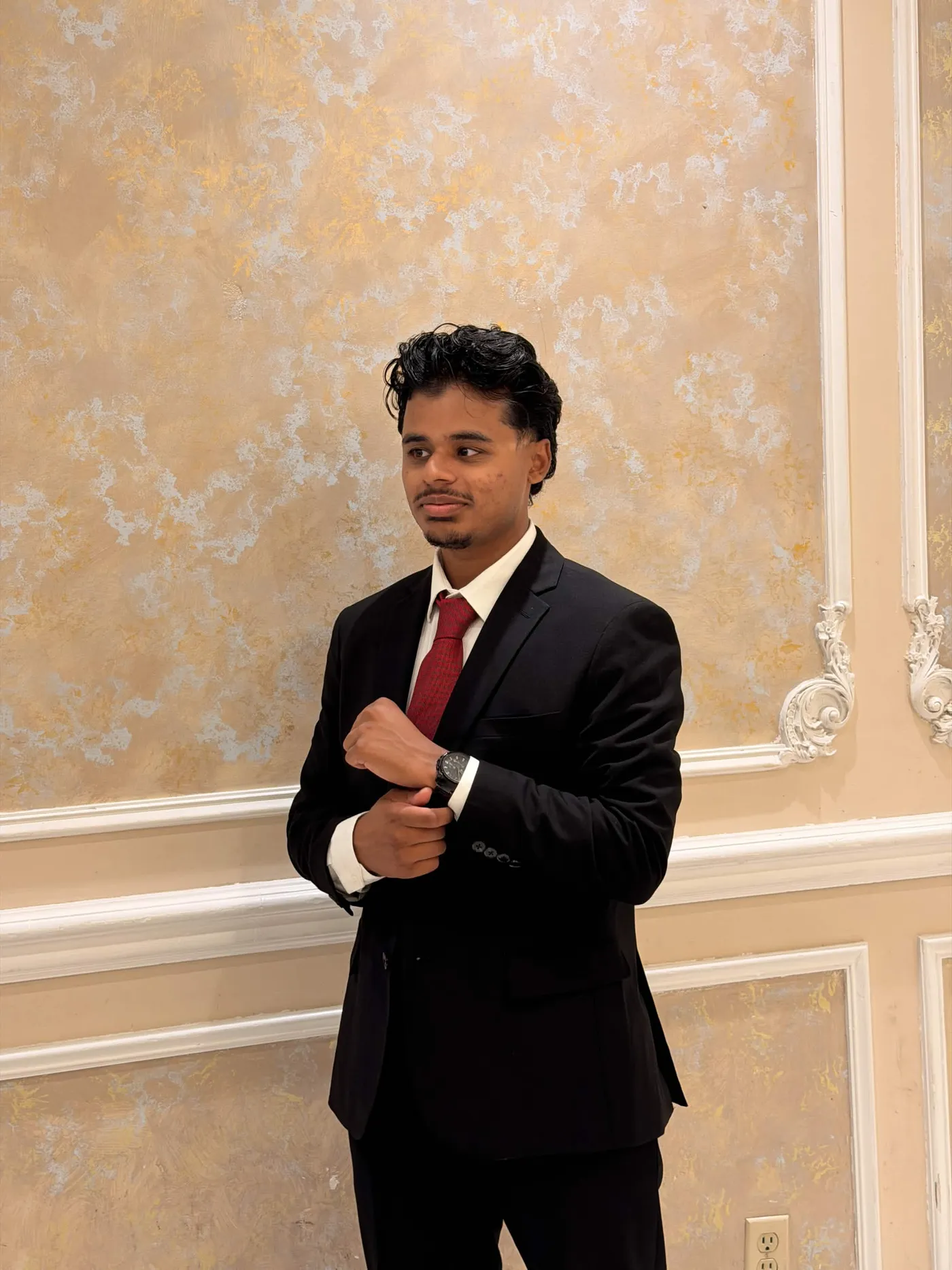 Hasan Zaman in a black suit and red tie